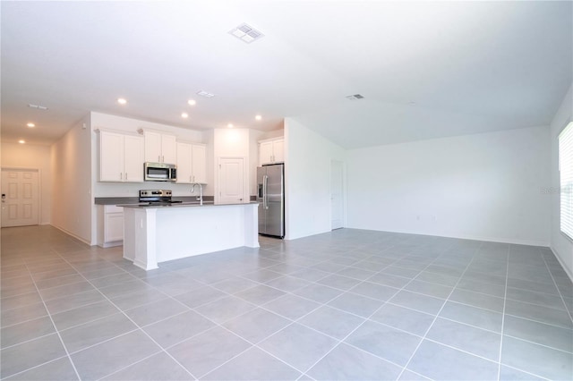 kitchen featuring white cabinetry, an island with sink, appliances with stainless steel finishes, and light tile patterned flooring