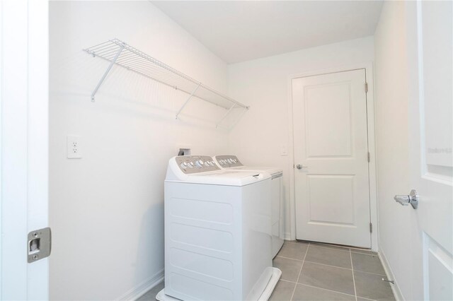 washroom featuring washer and clothes dryer and light tile patterned floors