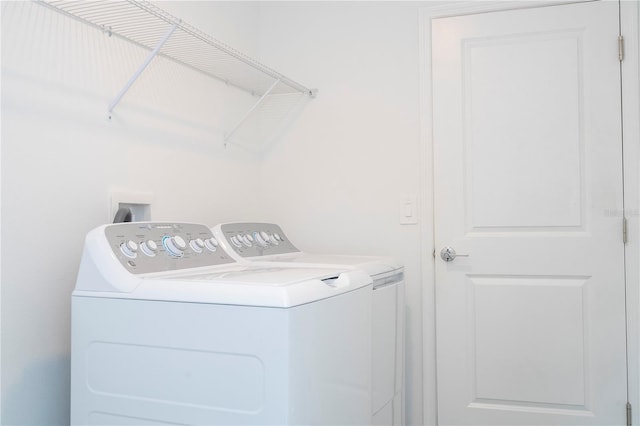 clothes washing area with separate washer and dryer