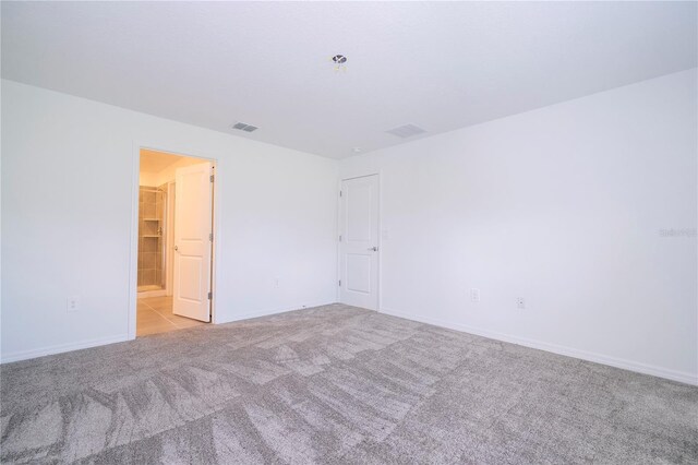 spare room featuring light colored carpet