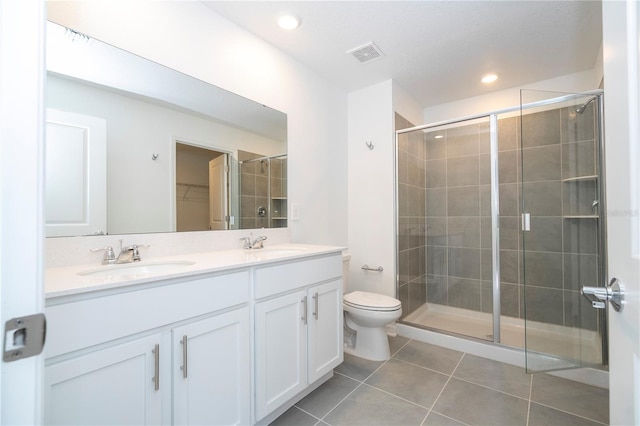 bathroom with tile patterned flooring, an enclosed shower, vanity, and toilet