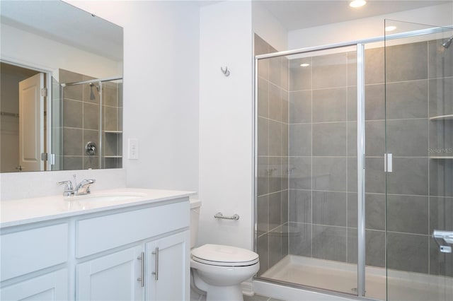 bathroom featuring vanity, toilet, and an enclosed shower