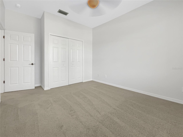 unfurnished bedroom with carpet flooring, ceiling fan, and a closet