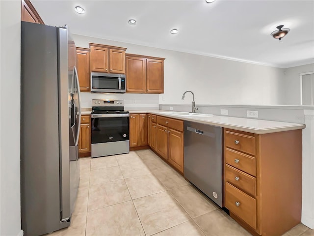 kitchen with appliances with stainless steel finishes, kitchen peninsula, sink, and light tile patterned floors