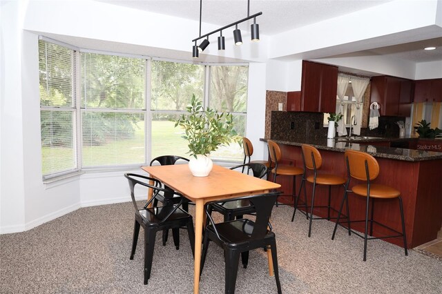 dining room with light colored carpet and indoor wet bar