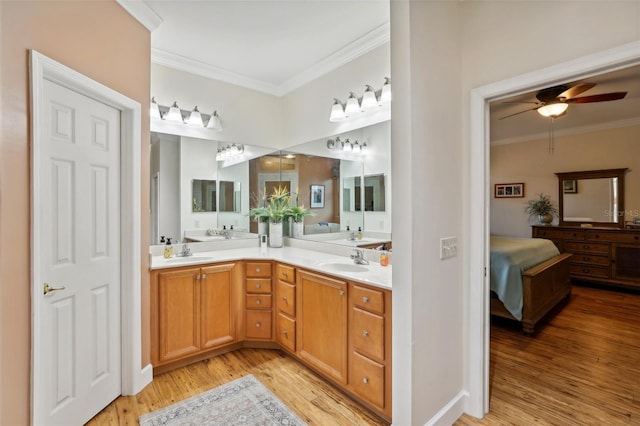 bathroom featuring wood-type flooring, vanity, ceiling fan, and ornamental molding