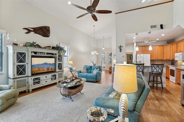 living room featuring ceiling fan, light hardwood / wood-style flooring, and high vaulted ceiling