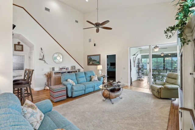 living room featuring ceiling fan, light hardwood / wood-style flooring, and high vaulted ceiling