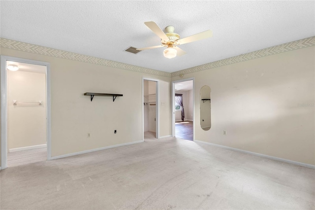 carpeted empty room featuring a textured ceiling and ceiling fan