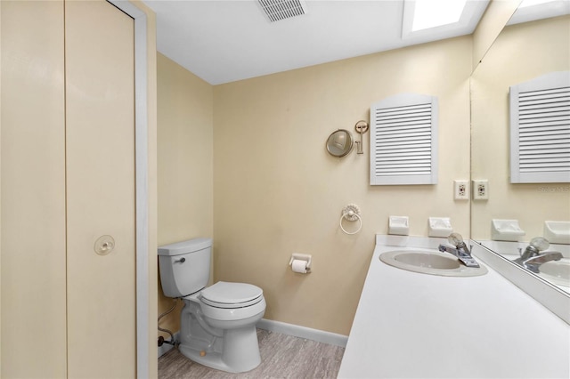 bathroom featuring vanity, toilet, and wood-type flooring