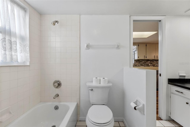 full bathroom featuring tiled shower / bath, vanity, toilet, and tile patterned floors