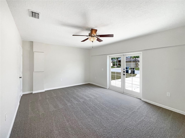 carpeted spare room with ceiling fan, french doors, and a textured ceiling