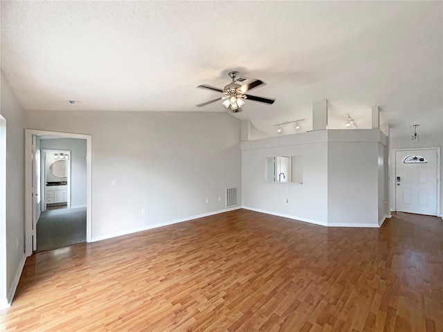 unfurnished living room featuring a textured ceiling, hardwood / wood-style flooring, ceiling fan, and lofted ceiling