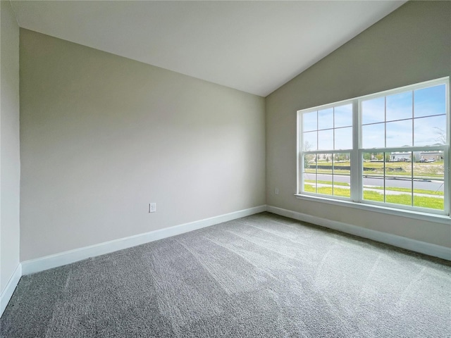 carpeted empty room with vaulted ceiling