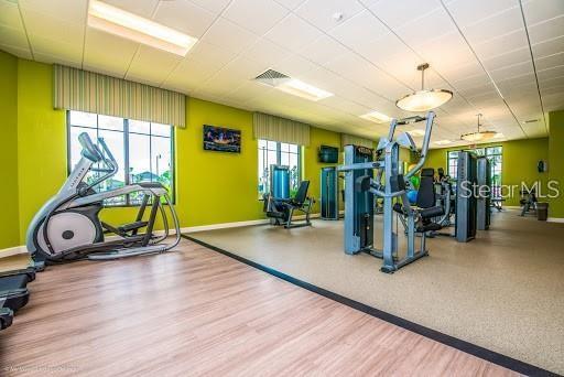 gym featuring baseboards, visible vents, and wood finished floors