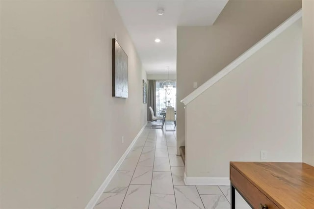 corridor featuring recessed lighting, stairway, a chandelier, marble finish floor, and baseboards