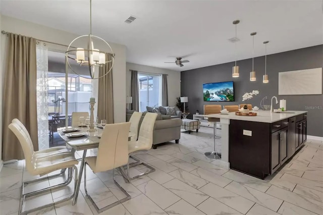 dining space with visible vents, ceiling fan with notable chandelier, and marble finish floor
