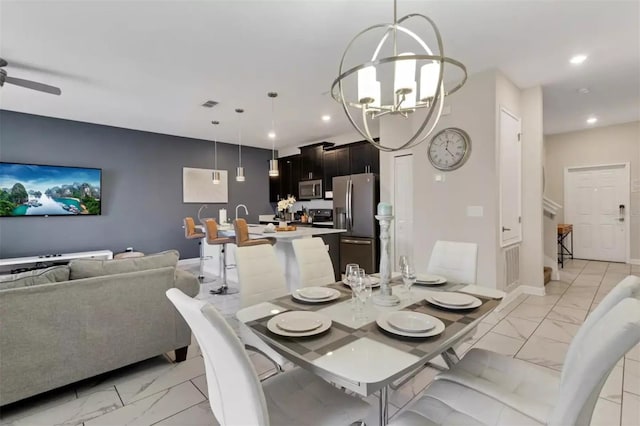 tiled dining space with ceiling fan with notable chandelier