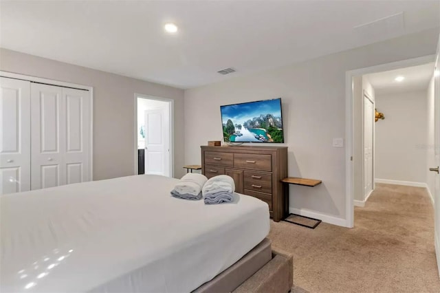 bedroom featuring light colored carpet and a closet