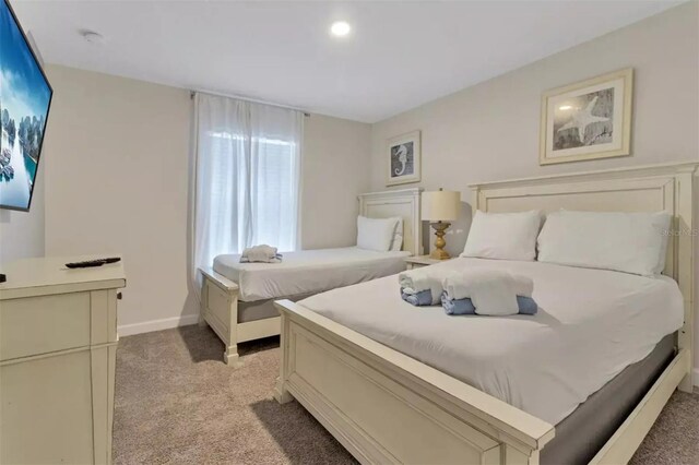 bedroom with baseboards and light carpet