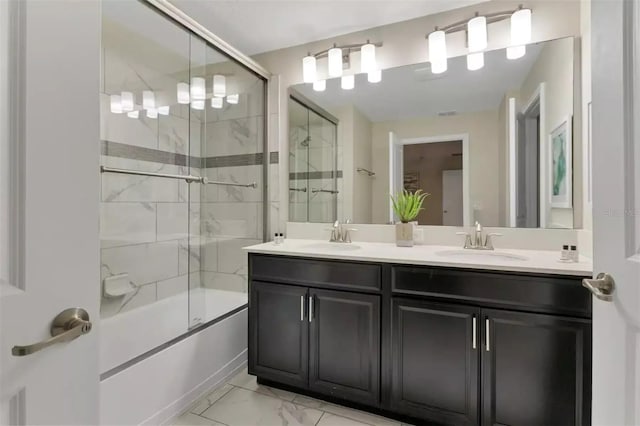 bathroom featuring shower / bath combination with glass door, marble finish floor, double vanity, and a sink
