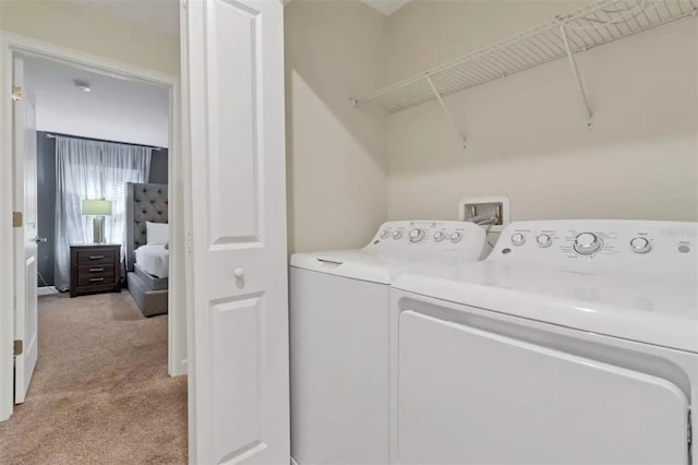washroom with washer and dryer, light carpet, and laundry area