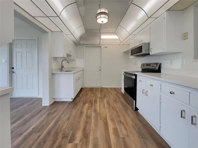 kitchen featuring appliances with stainless steel finishes, light hardwood / wood-style floors, sink, and white cabinets