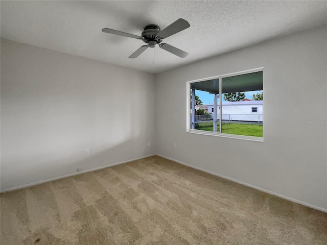 carpeted spare room featuring a textured ceiling and ceiling fan