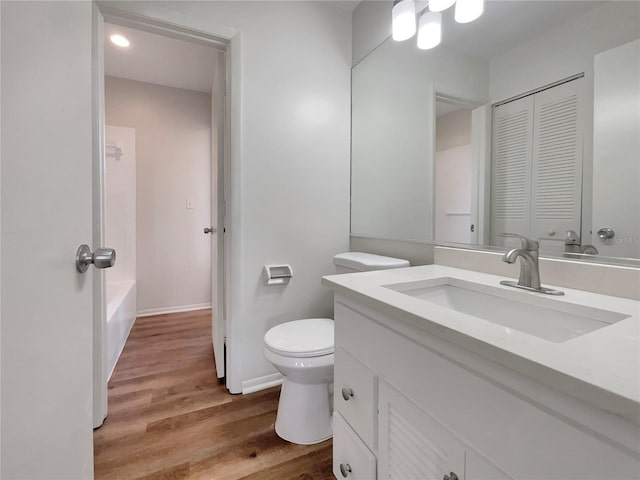 full bathroom with shower / tub combination, vanity, toilet, and hardwood / wood-style floors