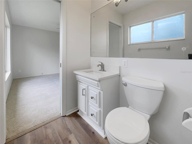 bathroom with wood-type flooring, vanity, and toilet