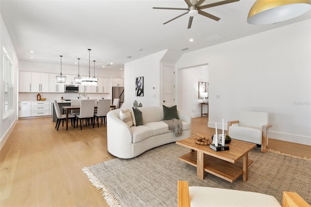 living room with ceiling fan and light wood-type flooring