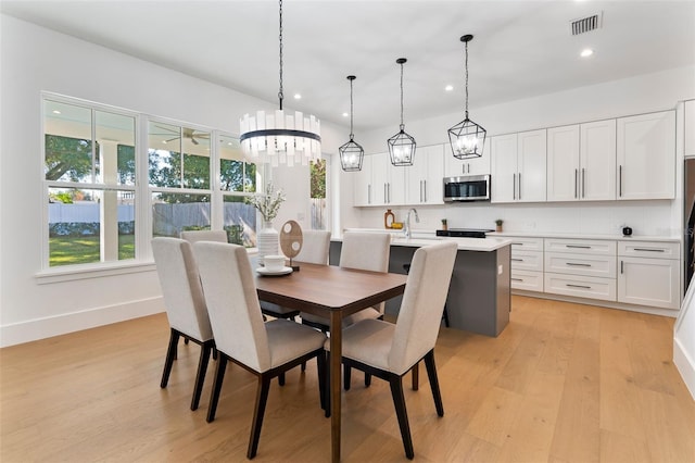 dining space with sink and light hardwood / wood-style floors