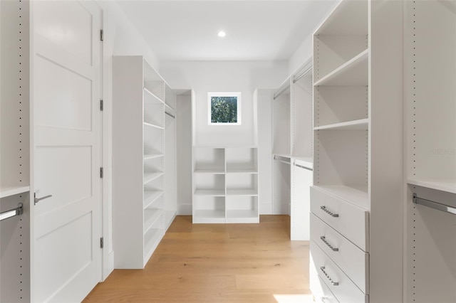 walk in closet with light hardwood / wood-style flooring