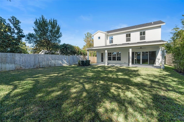 back of property featuring a yard, a patio area, and ceiling fan