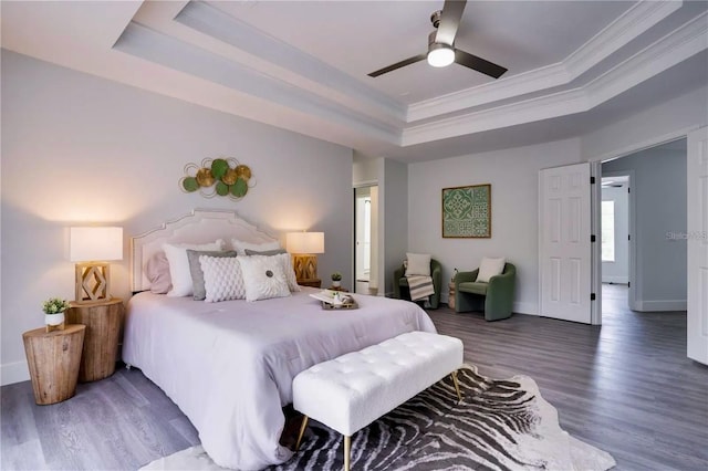 bedroom with a raised ceiling, ornamental molding, hardwood / wood-style floors, and ceiling fan