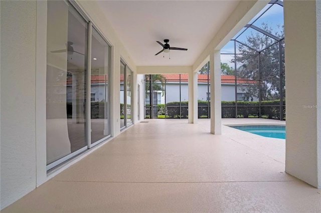 view of patio featuring glass enclosure and ceiling fan