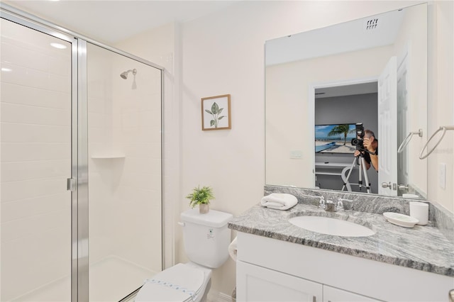 bathroom with a shower with shower door, vanity, and toilet