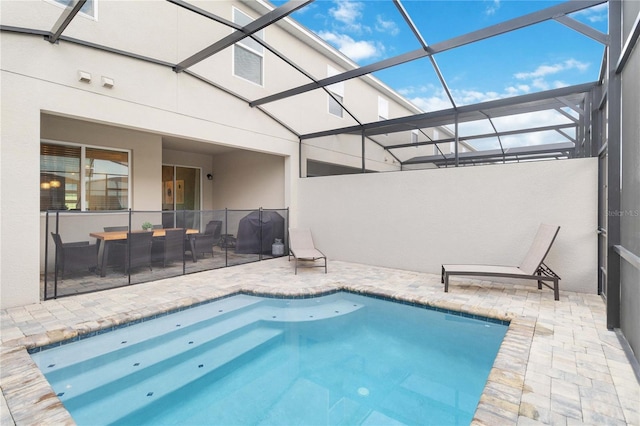 view of swimming pool with a patio and glass enclosure