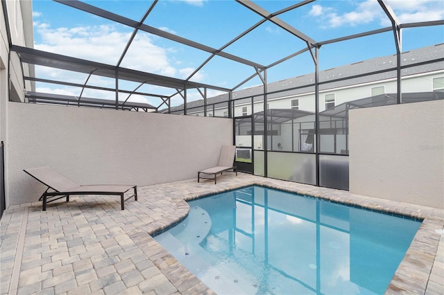 view of swimming pool featuring a patio and glass enclosure