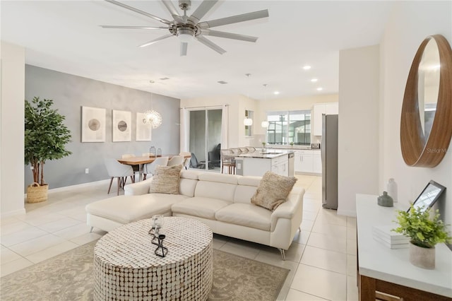 living room featuring sink, light tile patterned flooring, and ceiling fan