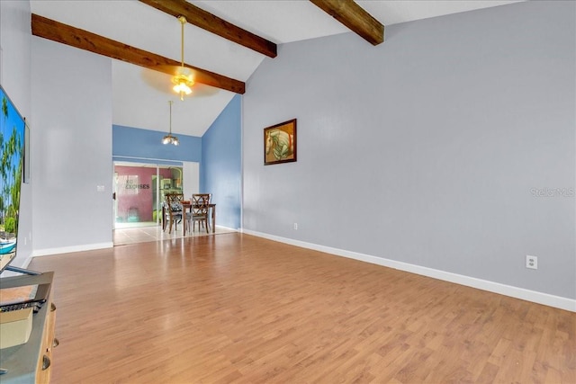 empty room featuring beam ceiling, high vaulted ceiling, and light wood-type flooring