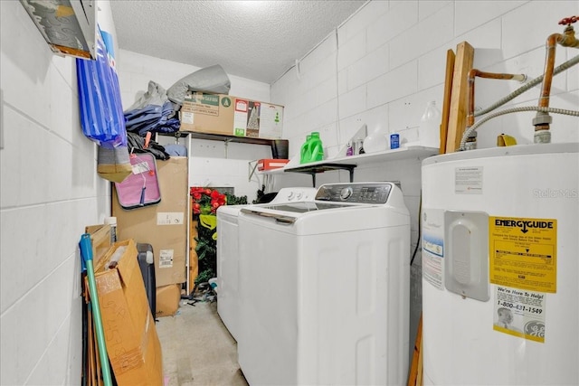 clothes washing area with washer and clothes dryer, water heater, and a textured ceiling