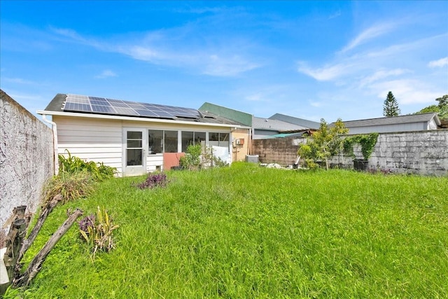 rear view of property featuring solar panels