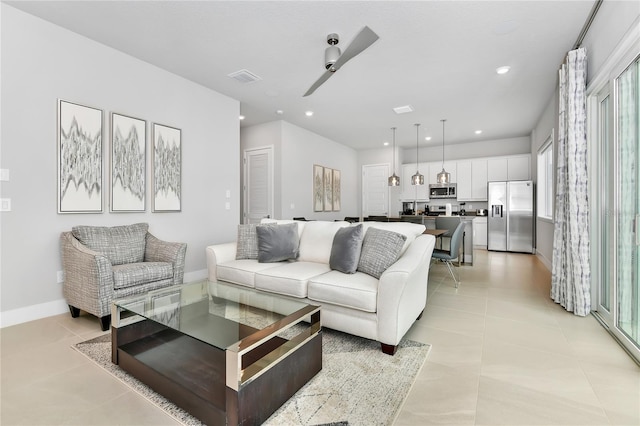 living room with ceiling fan and light tile patterned floors