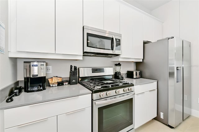 kitchen with light countertops, white cabinets, and appliances with stainless steel finishes