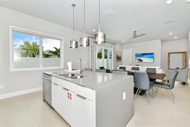 kitchen with visible vents, open floor plan, a center island with sink, white cabinets, and a sink