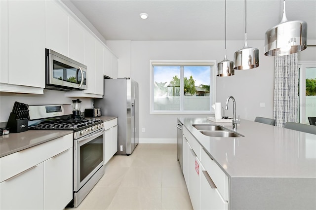 kitchen featuring white cabinetry, appliances with stainless steel finishes, hanging light fixtures, light tile patterned flooring, and sink