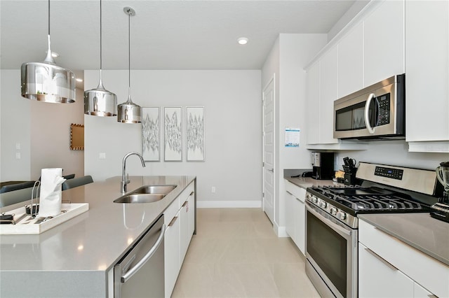 kitchen featuring white cabinetry, appliances with stainless steel finishes, pendant lighting, light tile patterned floors, and sink