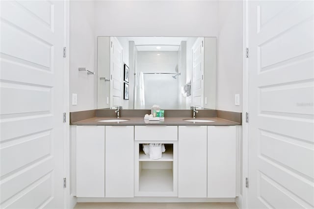 bathroom featuring double vanity, curtained shower, and a sink