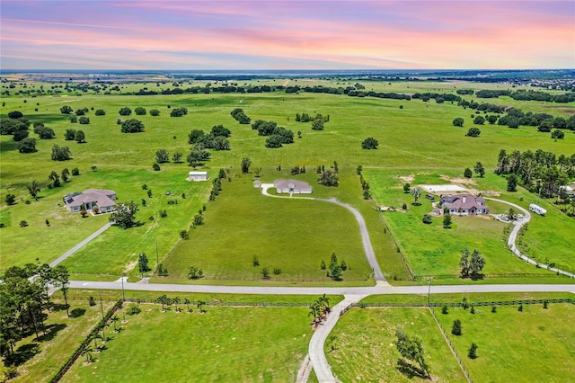 aerial view at dusk with a water view and a rural view